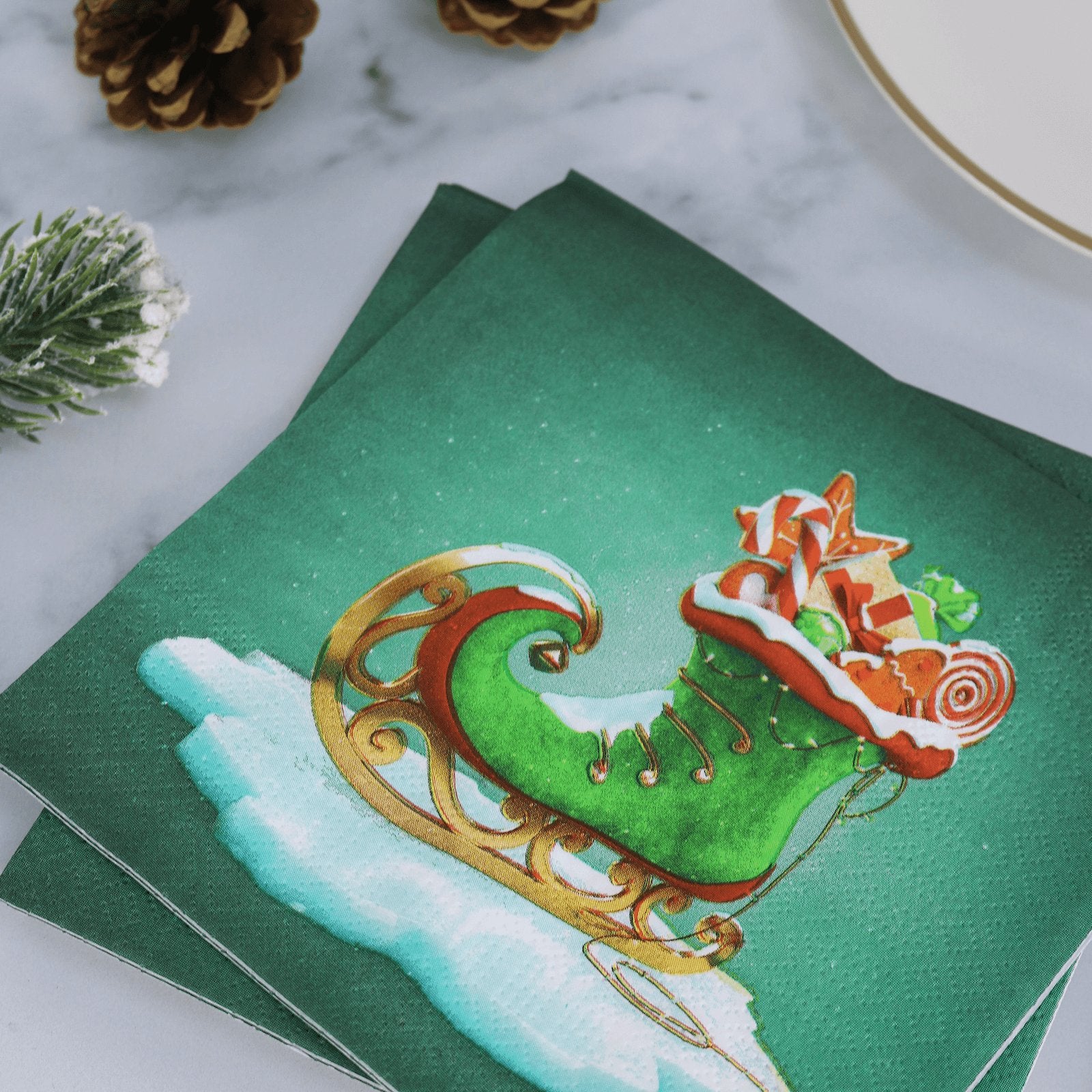 green elf boot napkins on christmas table bside gold trim plate